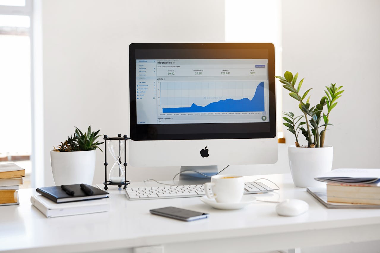 home-hero A clean, contemporary workspace featuring a desktop with analytics on the screen and plants for a fresh look.