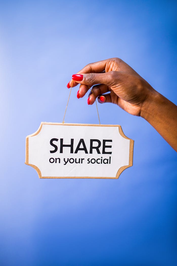 why-choose-us Close-up of a hand holding a 'Share on your social' sign on a vibrant blue backdrop.